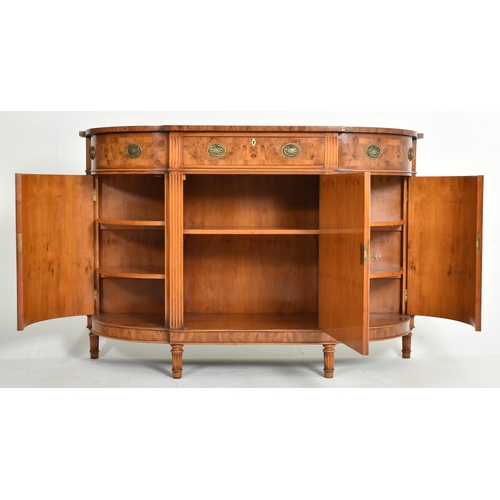 412 - Titchmarsh & Goodwin - a George III Revival yew wood bow front sideboard credenza. The sideboard... 