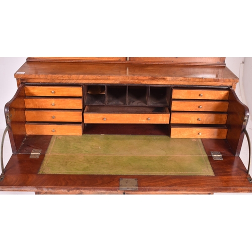 415 - A George III early 19th century mahogany secretaire bookcase. The bookcase having a flared pediment ... 