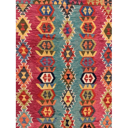 437 - A 20th century Persian Anatolian Turkish Kilim floor carpet rug. The rug having a central panel with... 