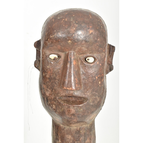 449 - An Indonesian carved wood Patung guardian sculpture. The figure having shell bead eyes with long nec... 