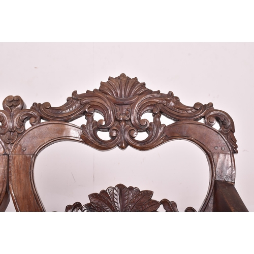 545 - An Indo - Portuguese manner hardwood and cane hall bench. The bench having a carved pierced back res... 