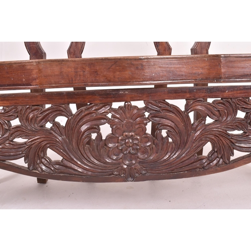 545 - An Indo - Portuguese manner hardwood and cane hall bench. The bench having a carved pierced back res... 