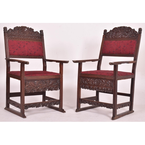 546 - A pair of 19th century carved oak hall carver chairs. Each armchair featuring carved floral and foli... 