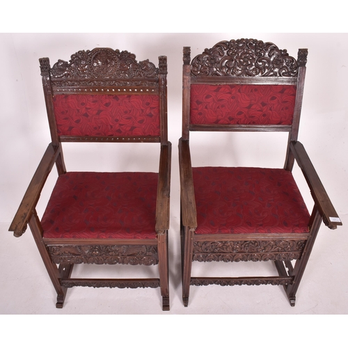 546 - A pair of 19th century carved oak hall carver chairs. Each armchair featuring carved floral and foli... 