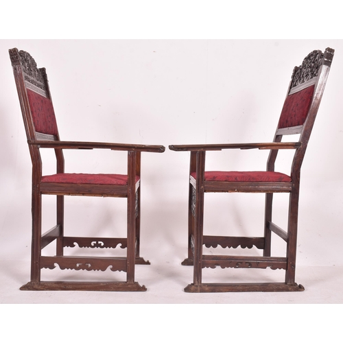 546 - A pair of 19th century carved oak hall carver chairs. Each armchair featuring carved floral and foli... 