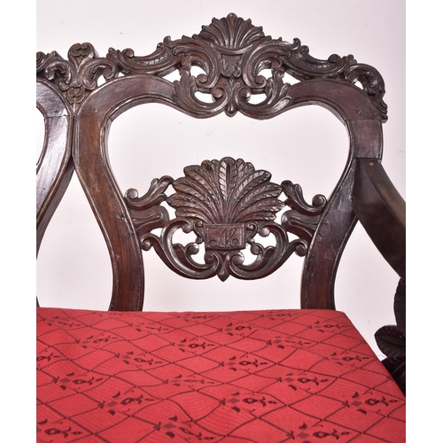 547 - An Indo - Portuguese manner hardwood hall bench settle. The bench having a carved pierced back rest ... 