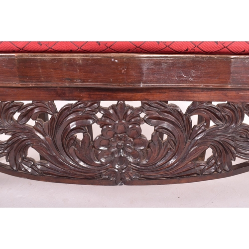 547 - An Indo - Portuguese manner hardwood hall bench settle. The bench having a carved pierced back rest ... 