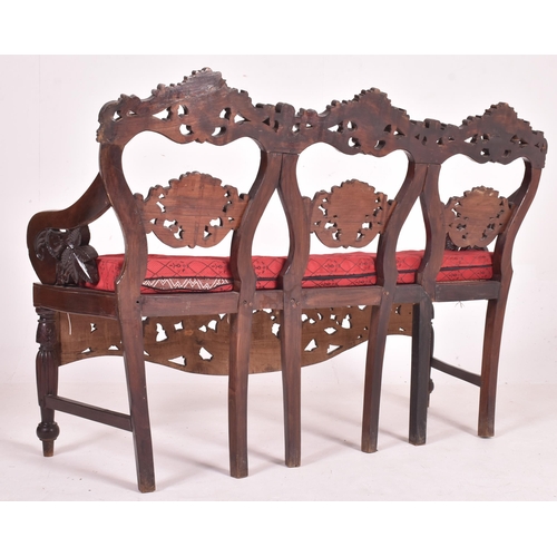 547 - An Indo - Portuguese manner hardwood hall bench settle. The bench having a carved pierced back rest ... 