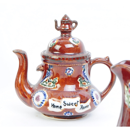 109 - Collection of early 20th century Measham bargeware including two teapots, two mugs and a milk jug / ... 