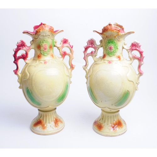 142 - Strasburg Ware - Two Edwardian twin handled ceramic vases, both with mother and child vignettes to t... 