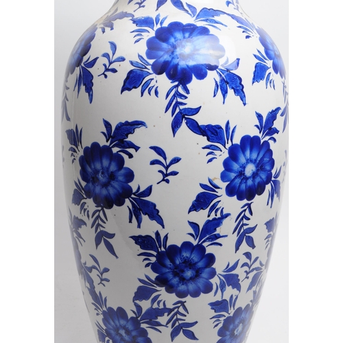 145 - Large late 20th century blue and white floral ceramic vase with a blue decorative border to the flar... 