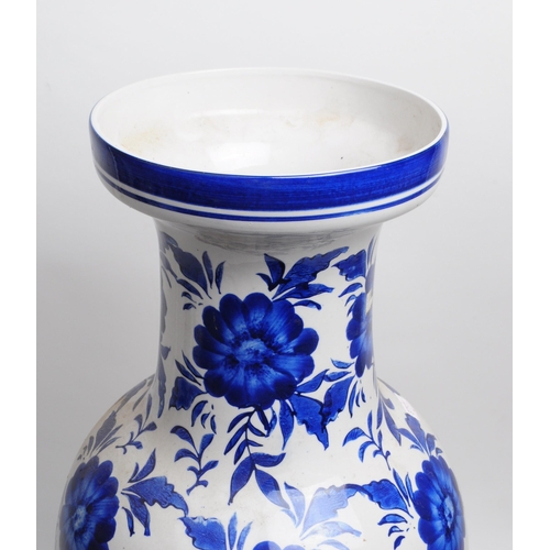 145 - Large late 20th century blue and white floral ceramic vase with a blue decorative border to the flar... 