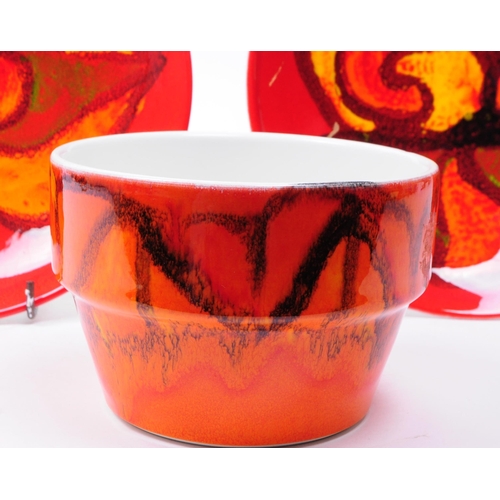 148 - Three 1970s Poole pottery Delphis patterned pieces comprised of a bowl and two plates in a red and o... 