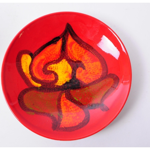 148 - Three 1970s Poole pottery Delphis patterned pieces comprised of a bowl and two plates in a red and o... 