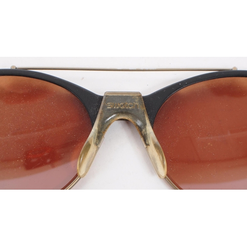 214 - Swatch - A pair of vintage 20th century Swatch sunglasses. The sunglasses having black molded plasti... 