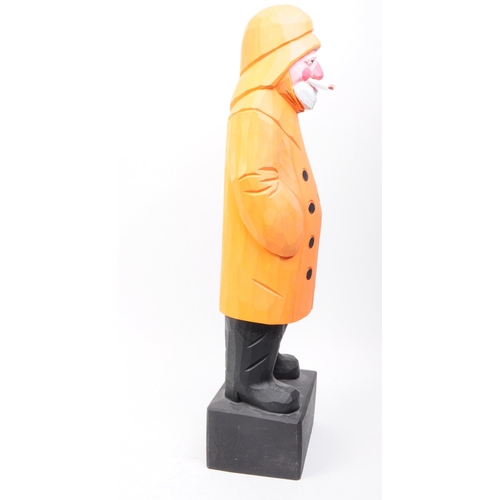 258 - Bounty Arts, Dartmouth. Hand carved wooden fisherman on black plinth base. Standing position with ci... 