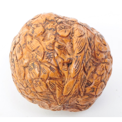 260 - A 20th century Chinese carved walnut shell One Hundred faces curio. The item made from a carved waln... 