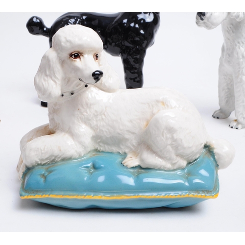 39 - Collection of 20th century porcelain dog figurines, comprised of a Beswick Poodle dog sitting on a b... 