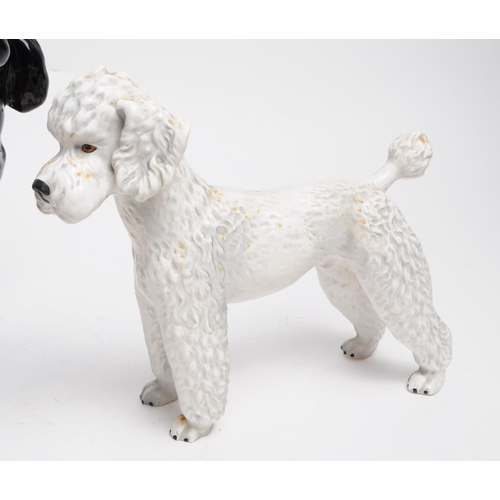 39 - Collection of 20th century porcelain dog figurines, comprised of a Beswick Poodle dog sitting on a b... 