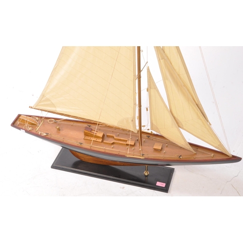 450 - A 20th century model yacht / sailing boat. Of wooden construction with a black and red painted finis... 