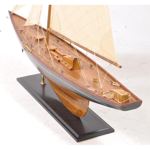 450 - A 20th century model yacht / sailing boat. Of wooden construction with a black and red painted finis... 