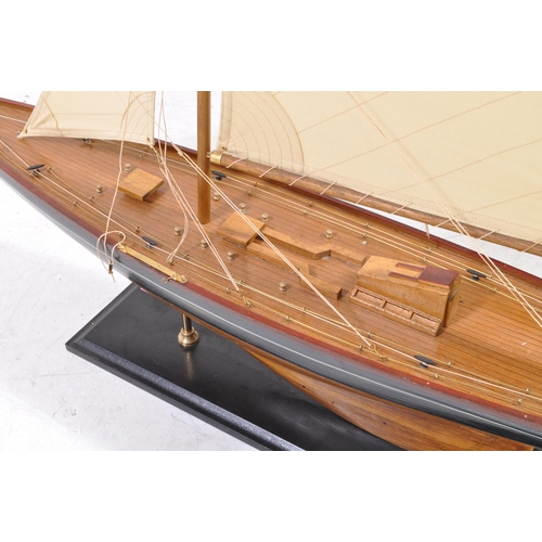 450 - A 20th century model yacht / sailing boat. Of wooden construction with a black and red painted finis... 