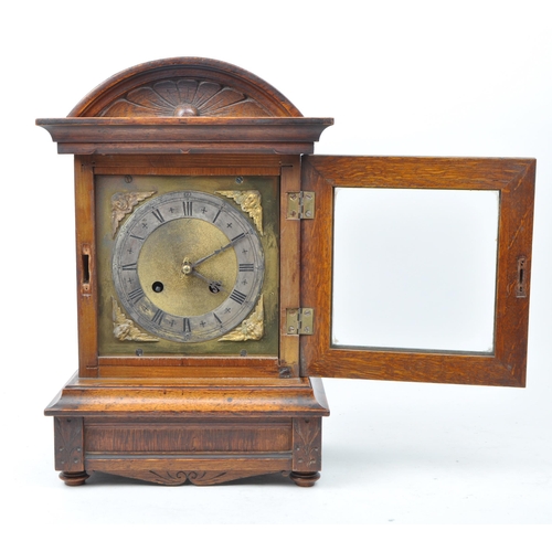 465 - An early 20th century oak cased eight day movement mantel clock. Moulded floral motif to top, with g... 