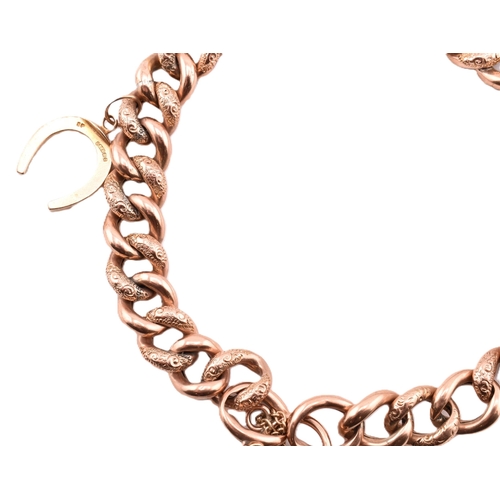 103 - A hallmarked 9ct gold engraved charm bracelet. The 9ct rose gold curb link bracelet having polished ... 