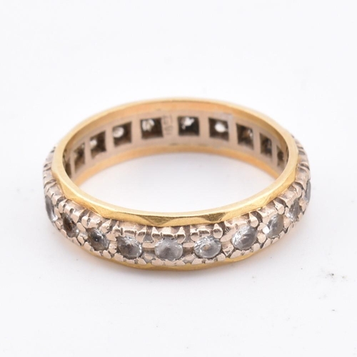 105 - An 18ct gold gem set eternity ring. Marked 18ct. Weight 4g. Size M.