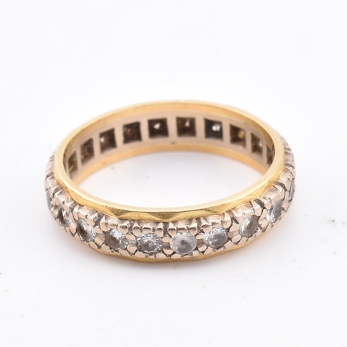 105 - An 18ct gold gem set eternity ring. Marked 18ct. Weight 4g. Size M.