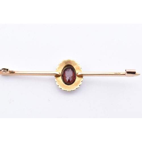 107 - A 15ct gold, garnet and pearl brooch pin. The 15ct yellow gold brooch pin set with a central collet ... 