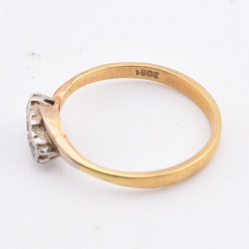 113 - An 18ct gold and diamond three stone crossover ring. Marked 18ct to inner shank. Weighs 3.1g. Size S... 