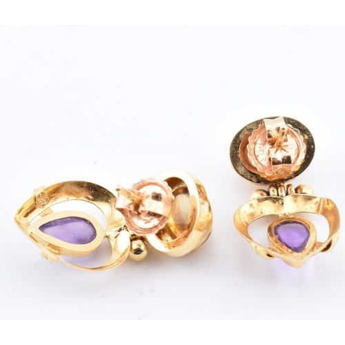 114 - A pair of 18ct gold citrine and amethyst pendant earrings. The 18ct yellow gold earrings set with te... 