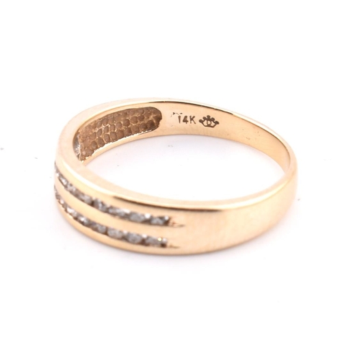 127 - A 14ct gold and diamond ring. The 14ct yellow gold ring set with two rows of eleven channel set roun... 