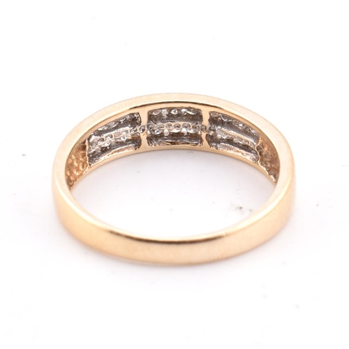 127 - A 14ct gold and diamond ring. The 14ct yellow gold ring set with two rows of eleven channel set roun... 