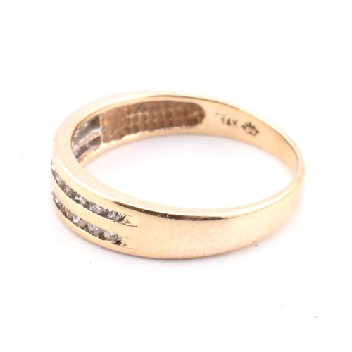 127 - A 14ct gold and diamond ring. The 14ct yellow gold ring set with two rows of eleven channel set roun... 