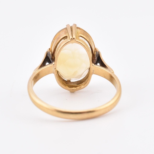 129 - An 18ct gold and citrine ring. The ring set with a single double claw set oval cut citrine to polish... 