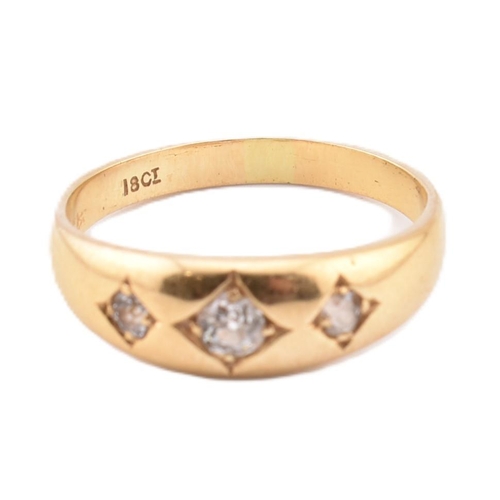 130 - An 18ct gold and diamond gypsy trilogy ring. The 18ct yellow gold ring having three old cut diamonds... 