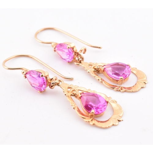 133 - A pair of 18ct gold and pink sapphire pendant earrings. The 18ct yellow gold pendant earrings set ea... 