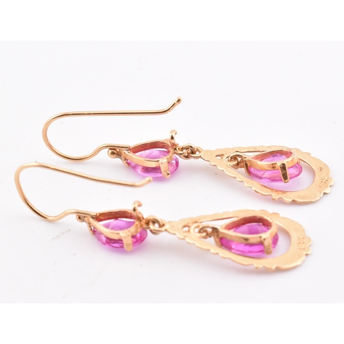 133 - A pair of 18ct gold and pink sapphire pendant earrings. The 18ct yellow gold pendant earrings set ea... 