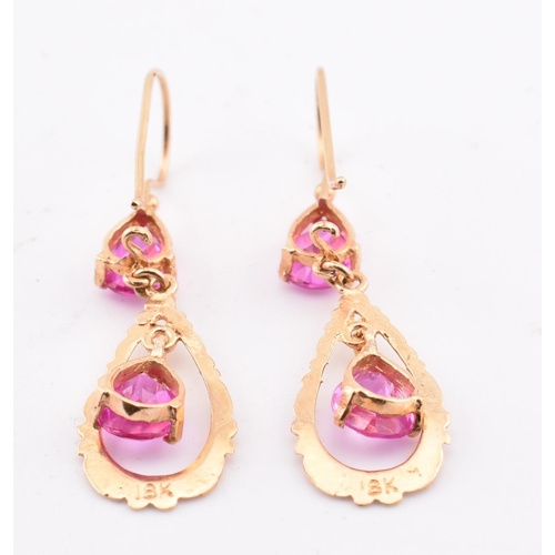 133 - A pair of 18ct gold and pink sapphire pendant earrings. The 18ct yellow gold pendant earrings set ea... 