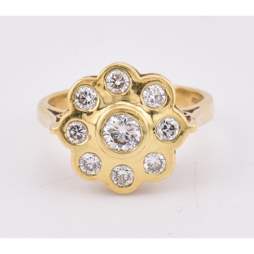 14 - A hallmarked 18ct gold and diamond 'hand made' cluster ring. The ring mounted with 9 bezel set round... 