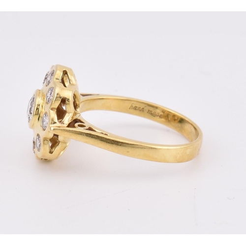 14 - A hallmarked 18ct gold and diamond 'hand made' cluster ring. The ring mounted with 9 bezel set round... 