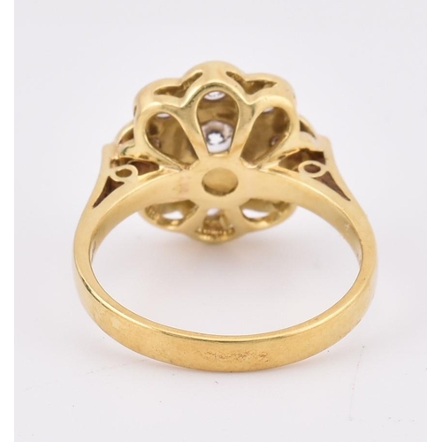 14 - A hallmarked 18ct gold and diamond 'hand made' cluster ring. The ring mounted with 9 bezel set round... 