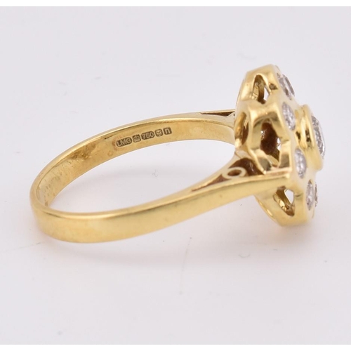 14 - A hallmarked 18ct gold and diamond 'hand made' cluster ring. The ring mounted with 9 bezel set round... 