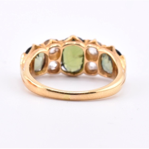 15 - A gold green sapphire and diamond three stone ring. The ring set with a central oval cut green sapph... 