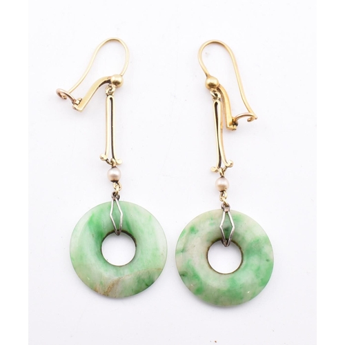 160 - A pair of gold and jade pendant earrings. The pendant earrings having an annular jade pendant surmou... 