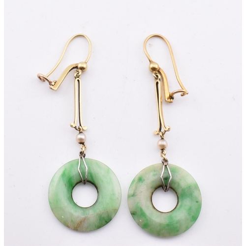 160 - A pair of gold and jade pendant earrings. The pendant earrings having an annular jade pendant surmou... 