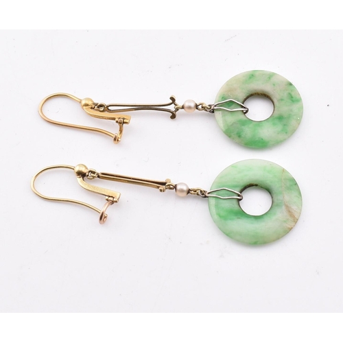 160 - A pair of gold and jade pendant earrings. The pendant earrings having an annular jade pendant surmou... 