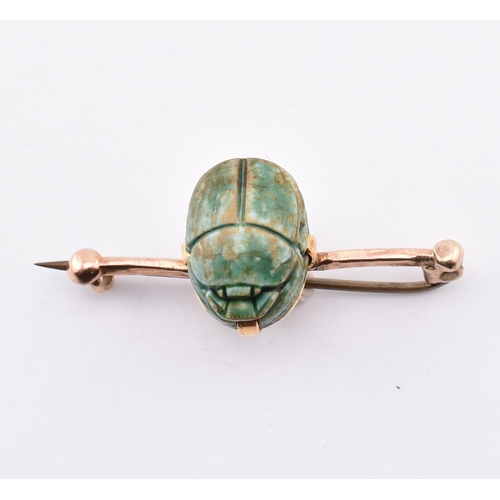 168 - A 14ct gold scarab beetle brooch pin. The 14ct bar brooch pin set with a central set scarab beetle t... 